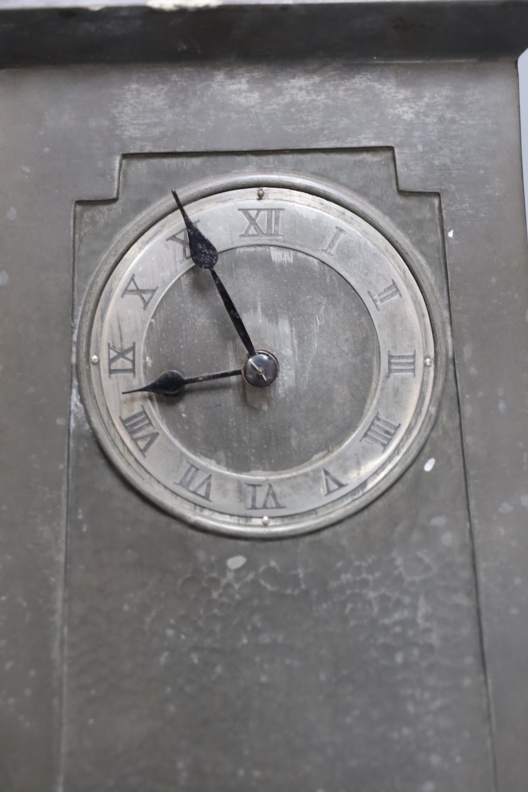 An Art Nouveau Liberty style hammered pewter mantel timepiece, Lenzkirch movement with key, 28 cms high.